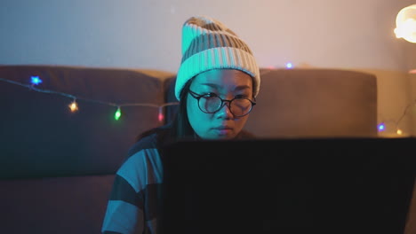 slow motion stock video of a female professional gamer playing online video games on a laptop from home