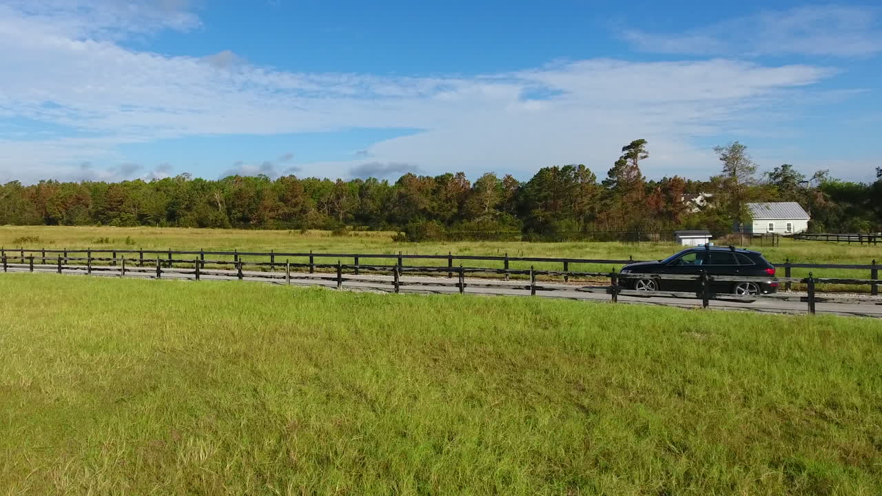 완벽한 하늘색 날에 목가적인 뒷길을 따라 여행하는 자동차