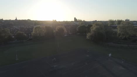 drone aerial rising view above british sunrise typical housing silhouette skyline