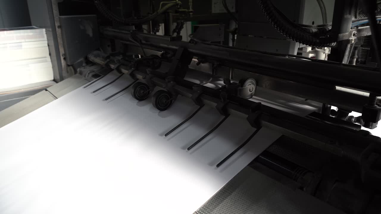 листы бумаги перемещаются заводской механизм типография машина печать книги на заводе