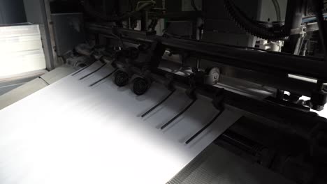 hojas de papel reubicadas por un mecanismo de fábrica máquina de imprenta imprimir libro en fábrica