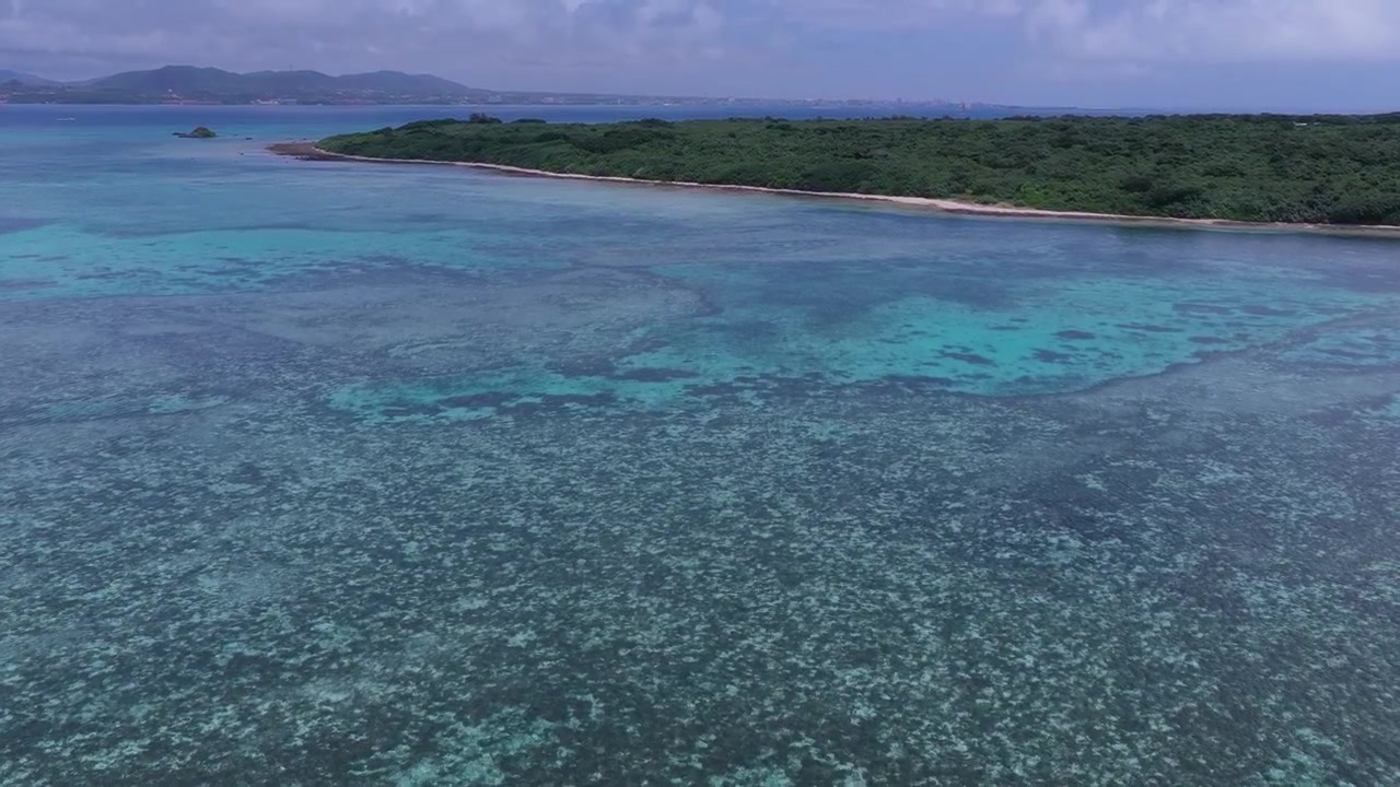 Riprese aeree orizzontali con carrellata in avanti sopra la vasta barriera corallina e le acque turchesi poco profonde vicino al molo Nishi, isola di Taketomi, Okinawa, Giappone