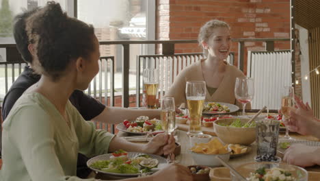 young woman having a good time with her multicultural group of friends at a dinner party