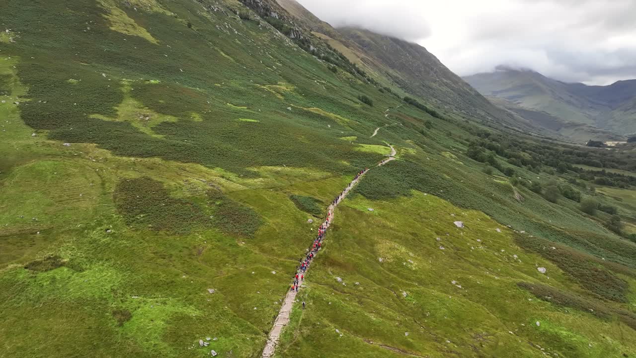 4K Drone shot of hikers climbing up to Ben Nevis, High angle view of group above Glen Nevis, Fort William