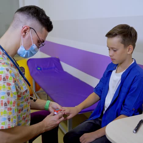 doctor listening to a teenage heart rate. special electrical appliance on finger. hi-tech technologies at pediatric clinic