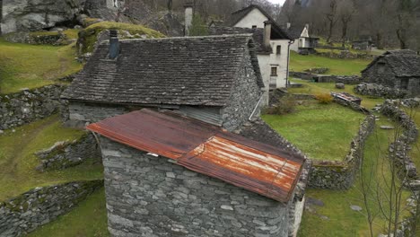 Flying-through-the-stone-houses-in-the-village-of-Cavergno,-in-the-district-of-Vallemaggia,-in-the-canton-of-Ticino,-in-Switzerland