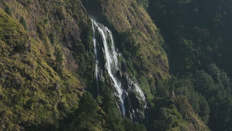 Drone-shot-of-Annapurna-region-in-Nepal-with-Huge-waterfall-Narchyang-flowing-from-top-of-the-cliff