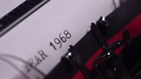 year 1968, typing in vintage typewriter on blank white paper, close up