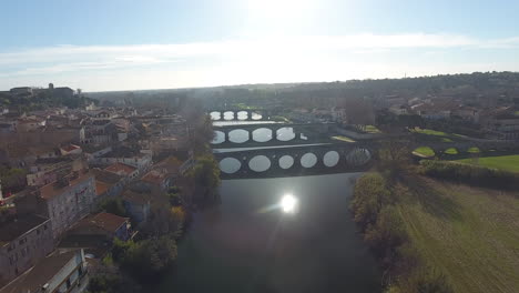 Reflejo-Del-Sol-Sobre-El-Río-Orbe-Con-Puentes-En-Beziers-Francia-Vista-Aérea-De-Drones