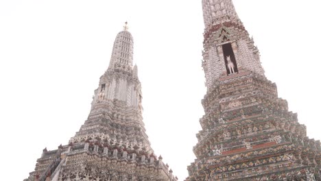 mirando hacia arriba a las torres de la pagoda detalladas en un complejo de templos budistas en el casco antiguo de rattanakosin de bangkok, tailandia
