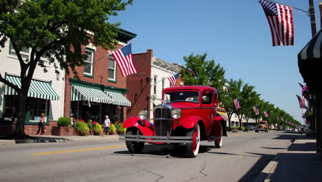a classic red car on a patriotic small town main street