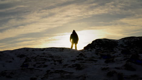Silhouettenaufnahme-Eines-Wanderers,-Der-Den-Sonnenaufgang-Auf-Dem-Gipfel-Des-Lovstakken,-Norwegen,-Genießt