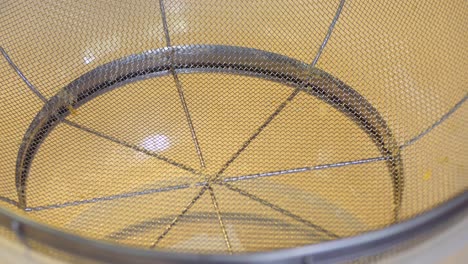 pouring passion fruit pulp into a sieve for processing