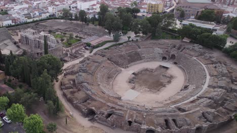 Aerial-view-orbiting-Roman-Amphitheatre-and-theatre-ruins-of-Merida-shot-above-ancient-excavation-archaeology