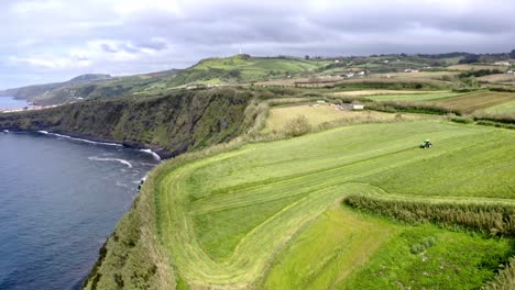 Tractor-Trabajando-En-Campo-Agrícola-En-Campo-Costero,-Azores,-Aéreo