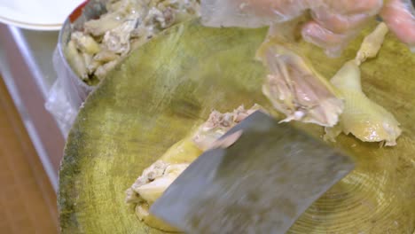 trabajador de la cocina cortando un ganso asado entero en una tabla de madera - vista superior
