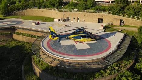 Expensive-modern-medical-helicopter-on-landing-pad,-aerial-orbit-view