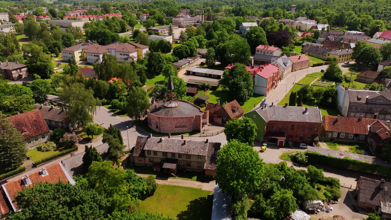 Cinematic aerial orbit reveals Aizpute Catholic Church in small Latvian town