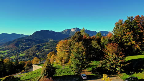 drone view rising from car park over trees to reveal stunning view over mountains in austria