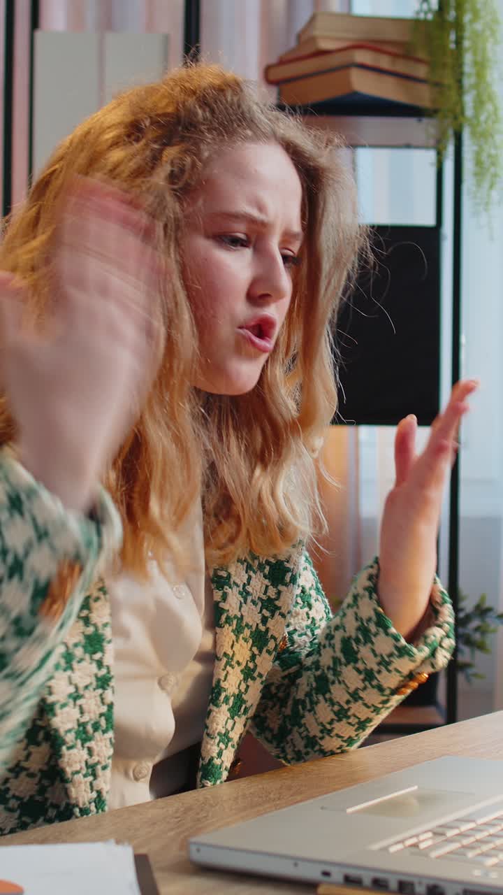 화가 난 사업가 여성이 노트북으로 논쟁하고 온라인으로 전화하고 가정 사무실에서 보고서 차트와 그래프를 표시합니다.