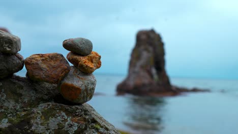 stack of rocks on the beach with sea stack in the background