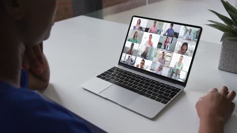 African-american-woman-talking-on-video-conference-on-laptop-with-office-colleagues-at-home