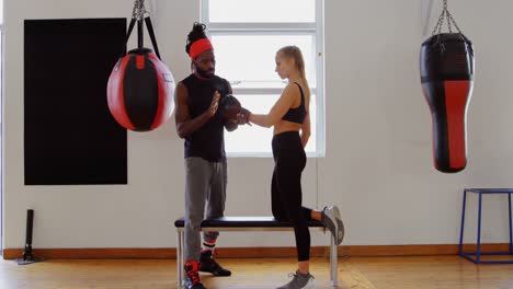 entrenador entrenando a una boxeadora en un estudio de fitness 4k