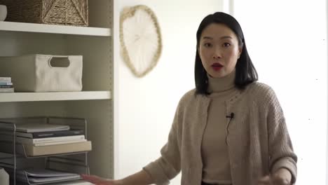 a stylish female speaker engages in dialogue about interior design and organization while showcasing a modern minimalist space