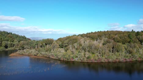 Aerial-zoom-out-of-Clonbur-Lakes-and-surrounding-scenery-against-a-blue-sky-in-Galway-County,-Ireland