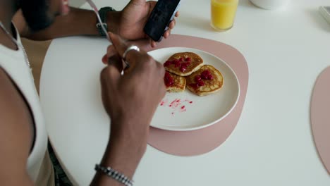 hombre tomando una foto de panqueques para las redes sociales