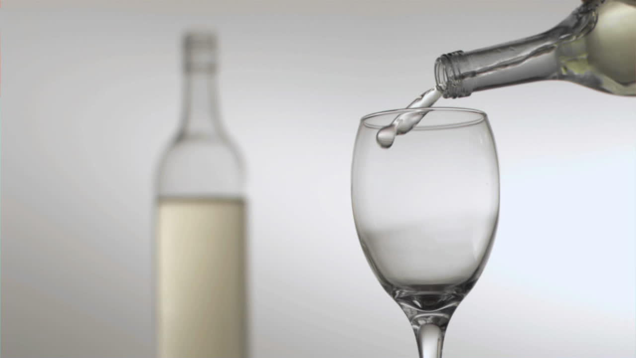 botella vertiendo vino blanco en cámara súper lenta