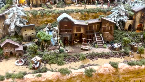 Vista-Cercana-Del-Caprichoso-Pueblo-En-Miniatura-Adornado-Para-Navidad,-Cubierto-De-Nieve,-Creando-Una-Escena-Festiva-Y-Encantadora-Para-Momentos-Divertidos-De-Vacaciones.