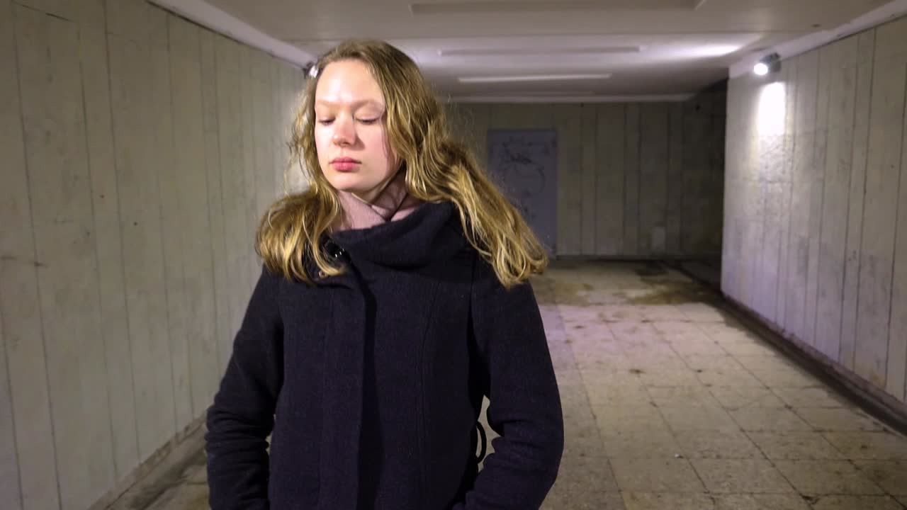 Ragazza che cammina nel sottopassaggio di notte