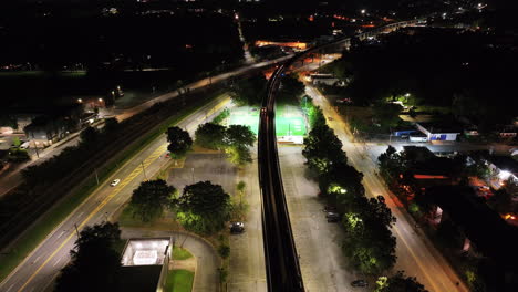 Aerial-ascending-footage-of-subway-train-passing-under