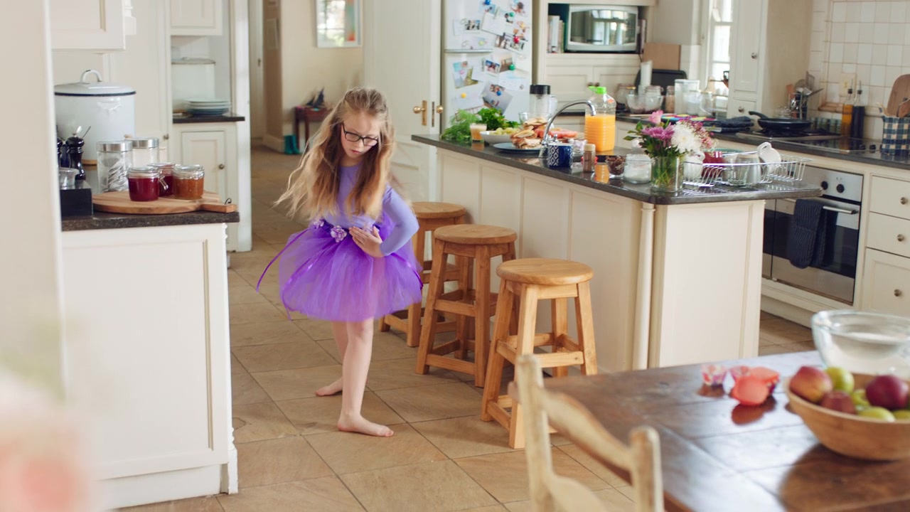 Bambina che Balla in Cucina con un Tutù Viola