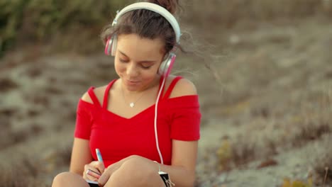 teenager girl on the beach writing on diary. shot in slow motion