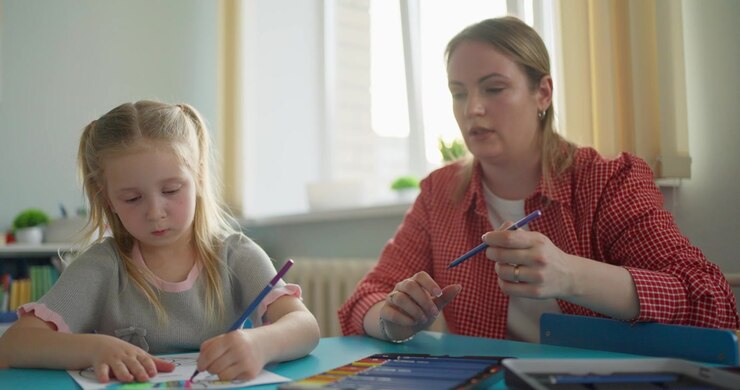 Bambina e donna adulta che colorano un disegno con le matite