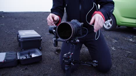 outdoor videographer leveling camera on gimbal, professional cameraman with equipment