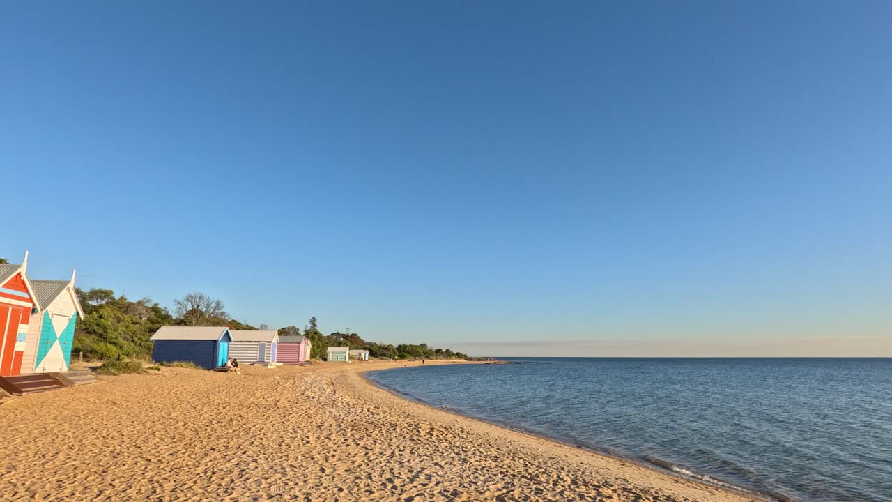 cabañas coloridas en la playa y una vista serena del océano
