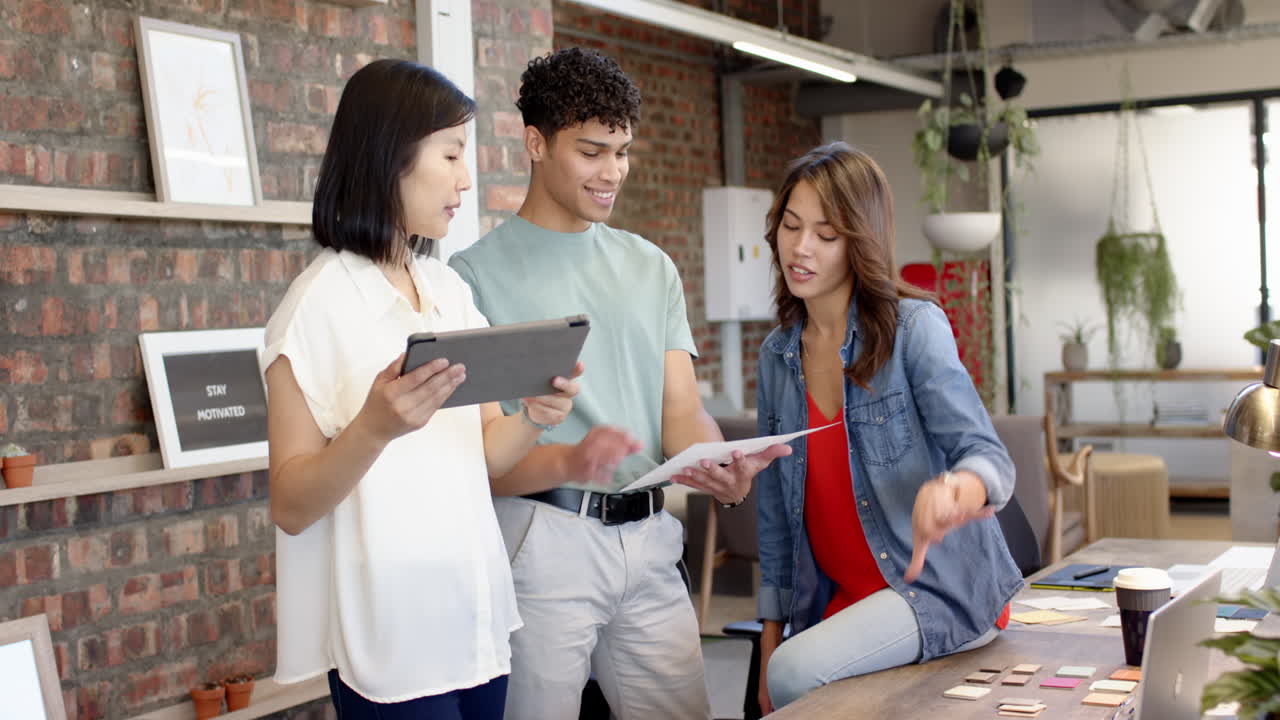 Discussing interior design ideas, multiracial team using tablet and samples in modern office