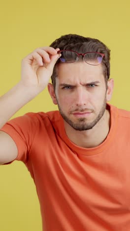 man adjusting glasses with a curious or confused expression