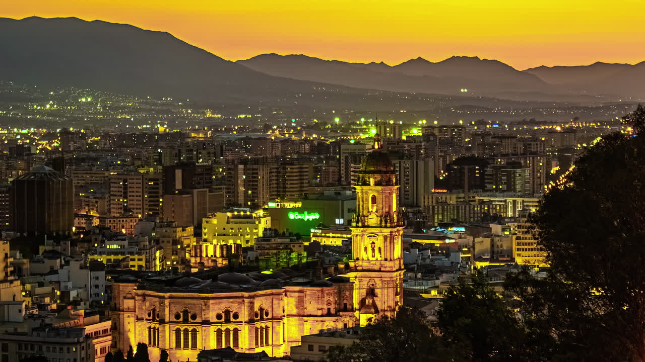 스페인의 산악 지형 근처에 있는 조명된 도시 풍경의 황혼 풍경