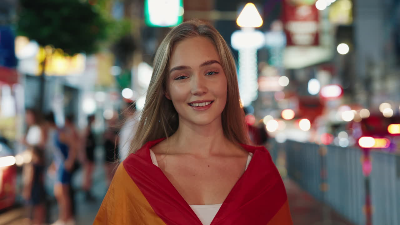Mujer con la bandera del Orgullo de noche