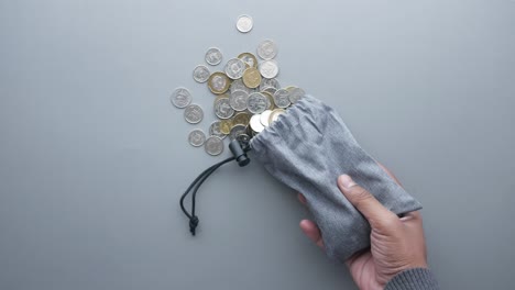 vista superior de las monedas derramándose de una bolsa pequeña