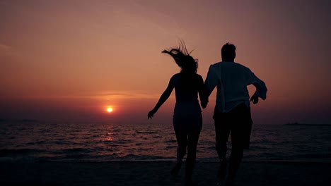 Junge-Leute-Haben-Spaß-Am-Meeresstrand-In-Zeitlupe-In-Der-Abenddämmerung