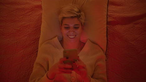 woman using phone in bed