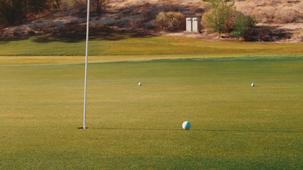 Colpo di golf che atterra vicino al green con molto effetto retroattivo, tiro d'approccio perfetto vicino alla buca.