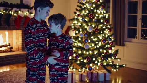 hermanos junto al árbol de navidad