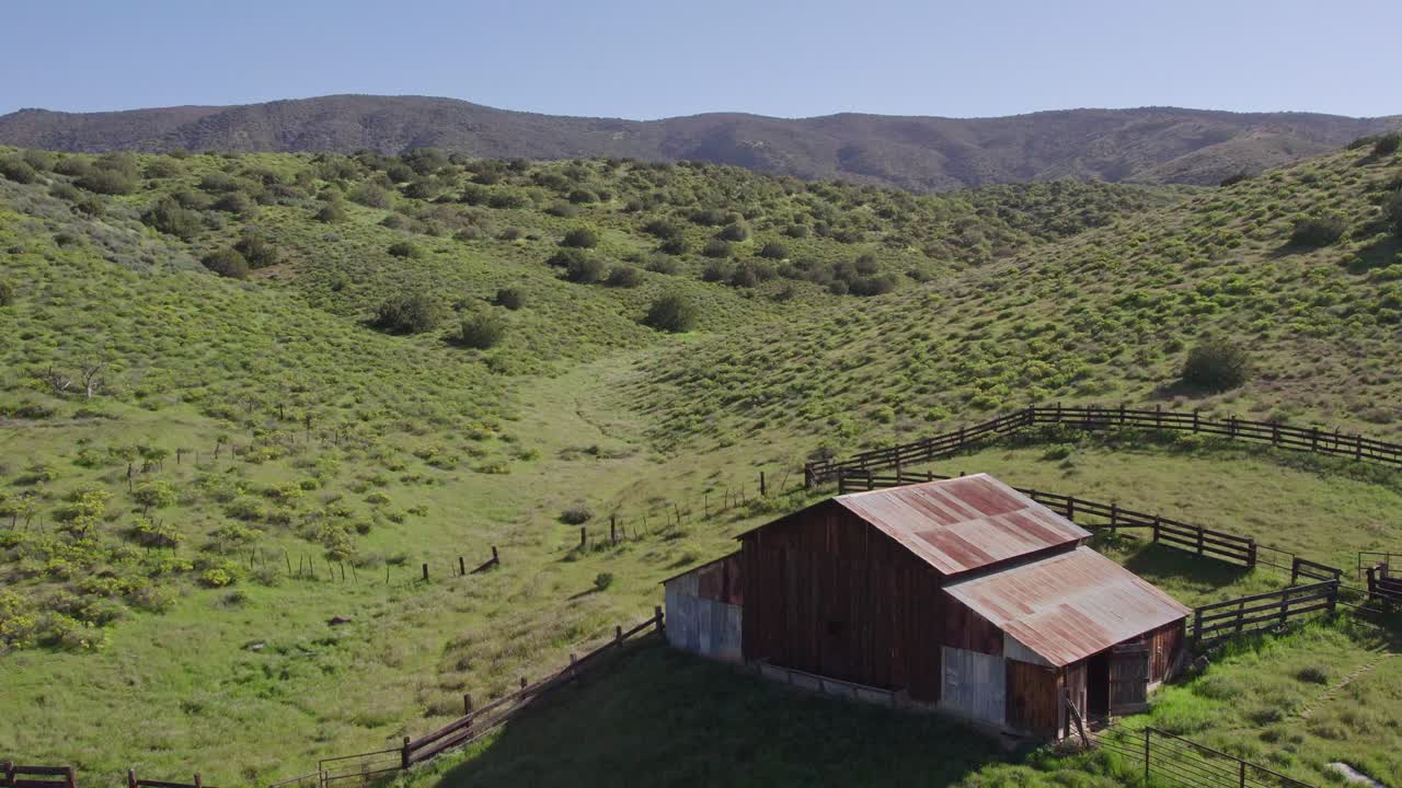 granero abandonado en las colinas verdes de la llanura de carrizo en california