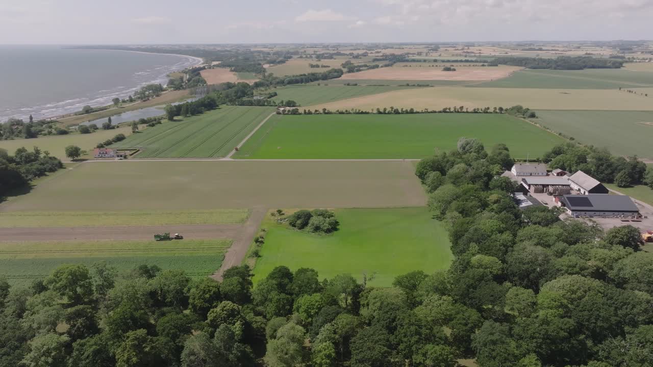 Vast green farmland on the coast of H&ouml;rte in Sweden, aerial orbit panorama